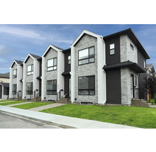 Reihenhäuser mit Ziegel- und Putzfassade sowie Rasenflächen