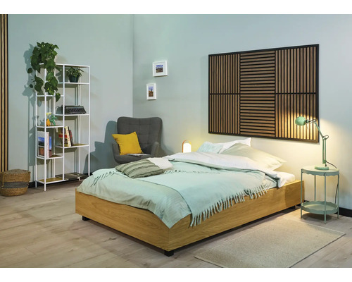 Helles Schlafzimmer mit Holzbett, Akustikpaneel an der Wand, Sessel und Regal