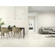 Heller Wohnraum mit Esstisch, Sofa und Fliesenboden in Marmoroptik