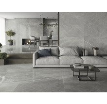 Heller Wohnraum mit Bodenfliesen und Wandfliesen in Marmoroptik, mit Couch, Tisch und Kamin.