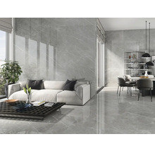 Heller Wohnraum mit grauen Marmorfliesen an Boden und Wand, Sofa, Esstisch und Fenster