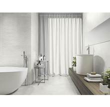 Helles Badezimmer mit freistehender Badewanne, Waschbecken und strukturierten Wandfliesen für ein modernes Design.