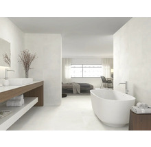 Helles Badezimmer mit Badewanne, Waschtisch und Zugang zum Schlafzimmer