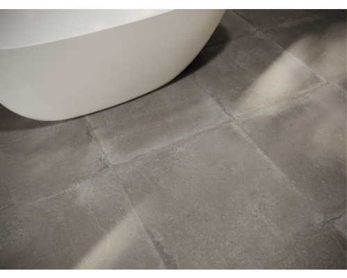 Detailaufnahme eines Badezimmers mit Bodenfliesen und Badewanne.