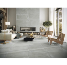 Wohnzimmer mit Fliesenboden, Kamin und hellen Möbeln.