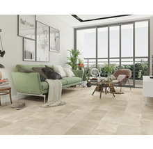 Wohnzimmer mit Sofa, Sessel, Couchtisch und großformatigen Bodenfliesen