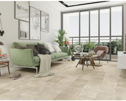 Wohnzimmer mit Sofa, Sessel, Couchtisch und großformatigen Bodenfliesen