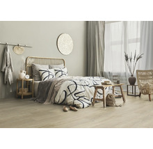 Helles Schlafzimmer mit Bett, Rattan-Elementen und dekorativen Accessoires für eine entspannende Atmosphäre
