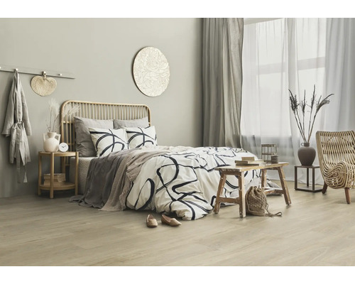 Helles Schlafzimmer mit Bett, Rattan-Elementen und dekorativen Accessoires für eine entspannende Atmosphäre