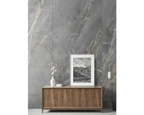 Wohnraum mit grauer Marmorwand, Holzkommode, gerahmtem Bild und Stehlampe