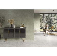 Heller, freundlicher Raum mit Fliesenboden, Kommode und Sitzgruppe.