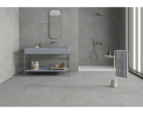 Modernes Badezimmer mit grauen Fliesen, Waschtisch, Spiegel und Handtuchhalter.
