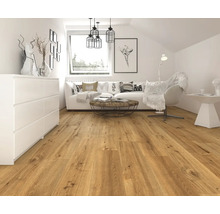 Heller Wohnraum mit Laminatboden in Holzoptik, weißer Kommode, Sofa und Dekoration