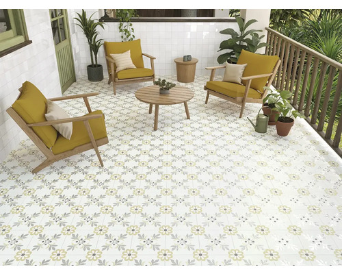 Terrasse mit floral gemusterten Fliesen, Holzmöbeln und Pflanzen