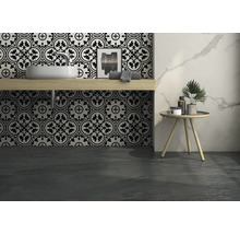 Badezimmer mit Waschbecken, Fliesen mit Muster und Dekoration auf einem Beistelltisch