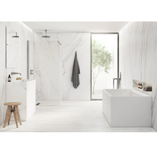 Helles Badezimmer mit Marmorwänden, Badewanne, Waschbecken und Holzhocker