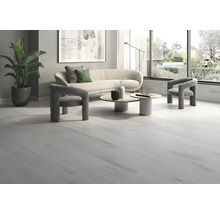 Heller Wohnraum mit Holzboden, Sofa, Sesseln und Couchtischen.