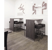 Stehtische mit Barhockern in einem hellen Raum mit Piktogrammen an der Wand