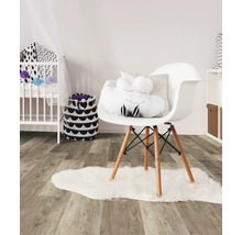 Ein Kinderzimmer mit einem Kinderbett, einem Stuhl und einem Teppich.