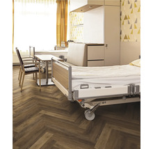 Krankenzimmer mit Betten, Stühlen und Holzboden in Fischgrätmuster