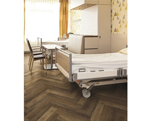 Krankenzimmer mit Betten, Stühlen und Holzboden in Fischgrätmuster
