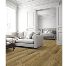 Helles Wohnzimmer mit Couch, Holzboden und Blick in ein Schlafzimmer.