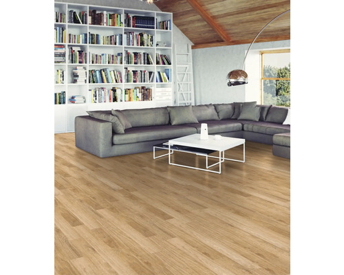 Wohnzimmer mit Holzboden, grauer Eckcouch, Bücherregal und weißem Couchtisch.