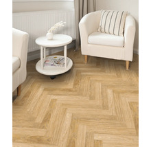 Wohnzimmer mit hellbraunem Fischgrätparkett, weißem Sessel und Beistelltisch