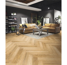 Wohnzimmer mit Fischgrätparkett, Ledersofa und Beistelltischen