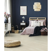 Schlafzimmer mit Bett, Nachttisch, Kommode und geflochtenem Hocker