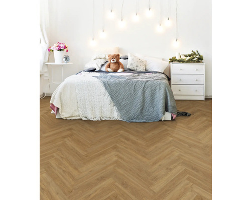 Helles Schlafzimmer mit Bett, Kommode und Fischgrätparkett