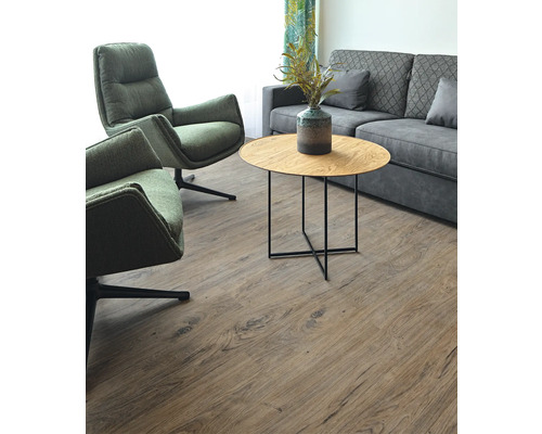 Wohnzimmer mit zwei Sesseln, einem Sofa und einem runden Tisch auf einem Holzboden.