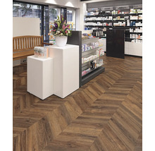 Innenraum einer Apotheke mit Holzfußboden im Fischgrätmuster und Regalen mit Produkten