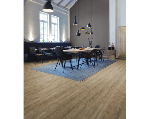Heller Raum mit Holzboden, Esstisch und blauer Teppich
