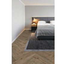 Schlafzimmer mit Bett, Nachttisch, Teppich und Parkettboden