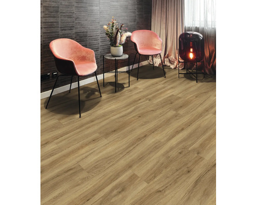 Wohnzimmer mit Holzboden, zwei Stühlen, einem Beistelltisch mit Blumen und einer Lampe