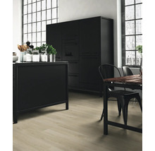 Schwarze Küche mit Kücheninsel, Esstisch und Stühlen in einem hellen Raum.