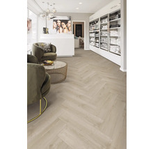 Innenraum mit hellem Boden im Fischgrätmuster, Sesseln und Verkaufsregalen