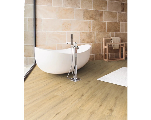 Helles Badezimmer mit freistehender Badewanne, Handtuchhalter und Steinwand