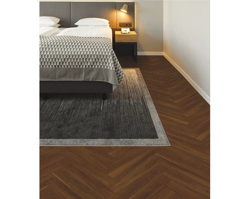 Schlafzimmer mit Bett und Teppich auf Holzboden