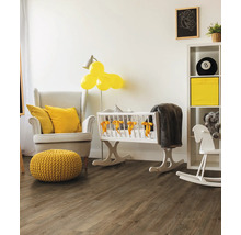 Helles Babyzimmer mit Sessel, Babywiege und Holzboden