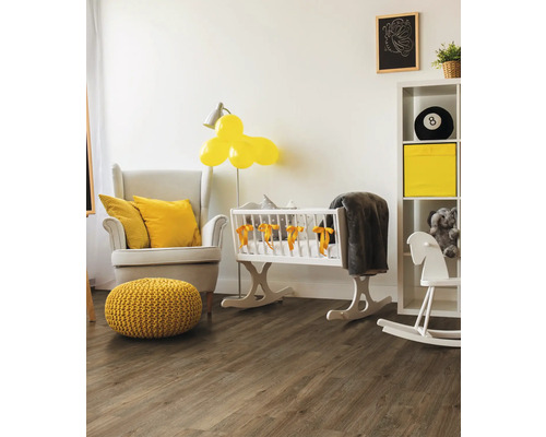 Helles Babyzimmer mit Sessel, Babywiege und Holzboden