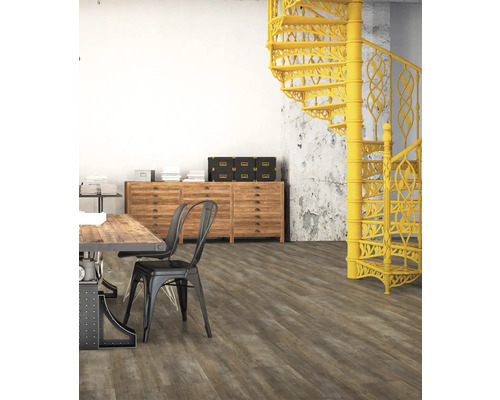 Szene mit Esstisch, Stühlen, Kommode und gelber Wendeltreppe in einem Raum mit Holzboden.