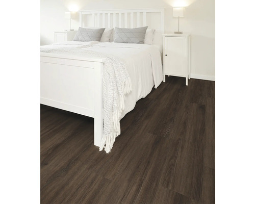 Schlafzimmer mit dunklem Holzboden, Bett und Nachttisch