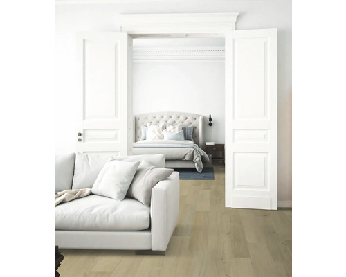 Wohnzimmer mit Sofa und Blick auf ein Schlafzimmer mit Bett