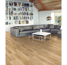 Wohnzimmer mit Laminatboden in Holzoptik, grauem Sofa, Bücherregal und weißem Couchtisch