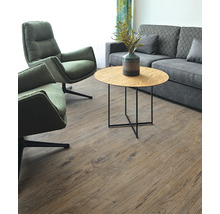 Wohnzimmer mit zwei Sesseln, Sofa und einem runden Tisch auf einem Holzboden