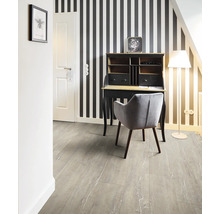 Schreibtisch mit Stuhl in einem Zimmer mit gestreifter Tapete und Laminatboden.