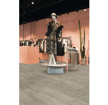 Innenraum eines Bekleidungsgeschäfts mit hellem Holzboden und Kleiderständern