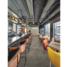 Innenraumansicht eines Restaurants mit Bar, Barhockern, Tischen und Stühlen.